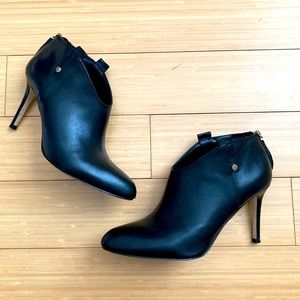 Black leather high heel booties with gold trim